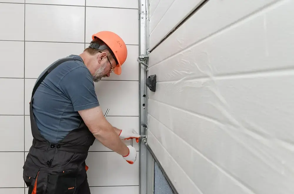 Technician torquing garage door track bolts