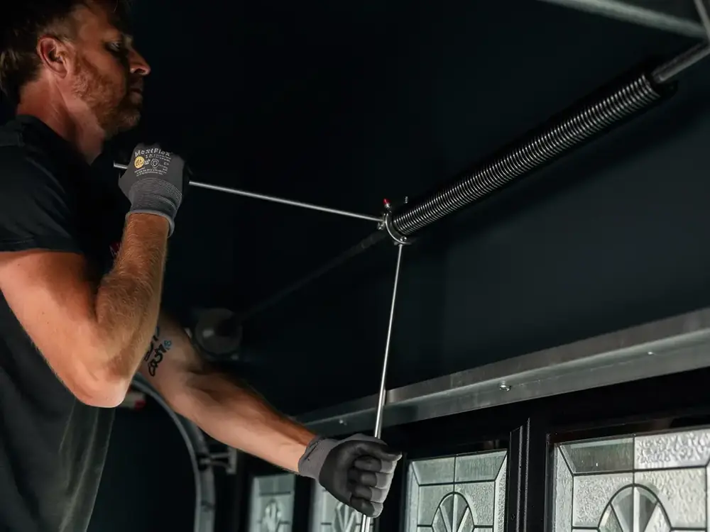 Technician winding a heavy-duty torsion spring